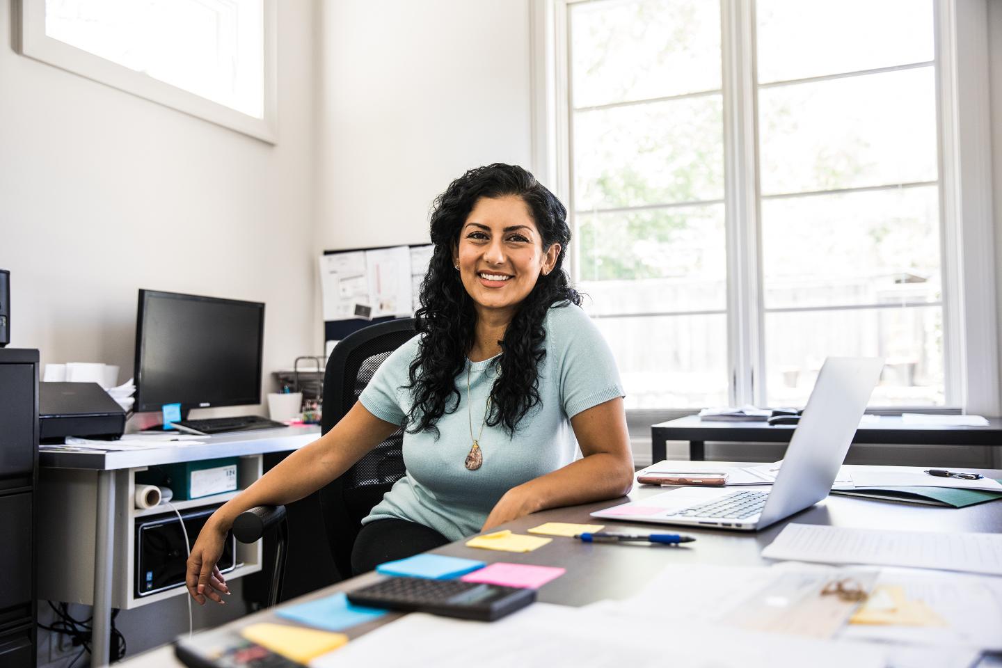 Happy and confident woman working in office.