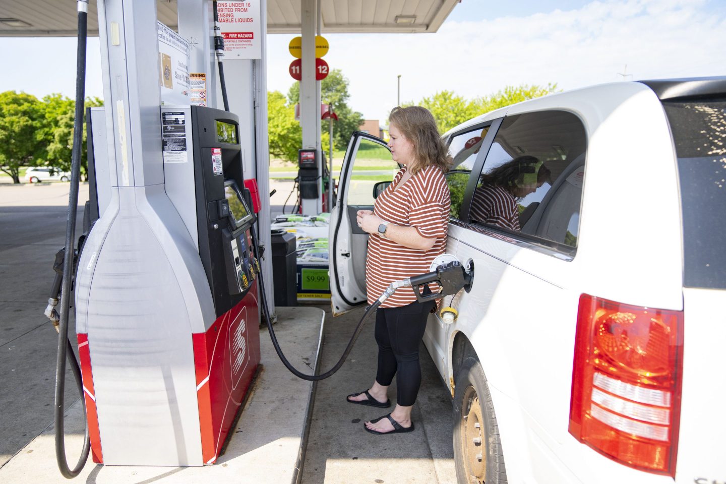 Elle Sammons pumps gas into her minivan Wednesday, August 17, 2022 at a Speedway gas station in Hastings, Minn.