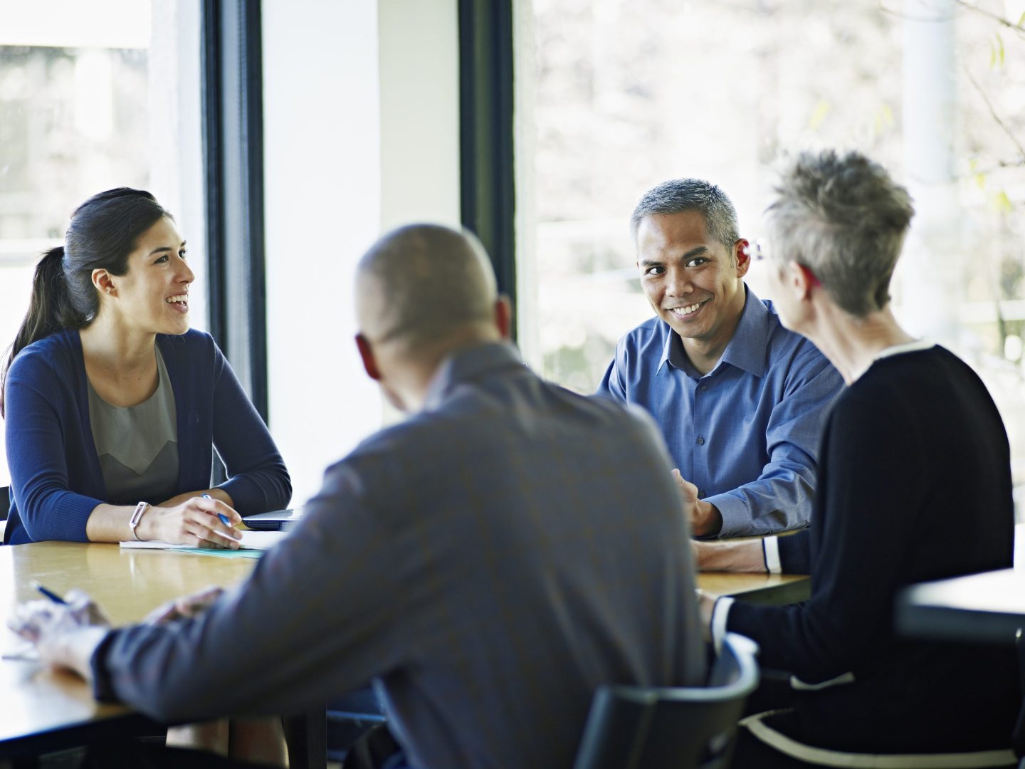 A diverse group of colleagues gather around a table
