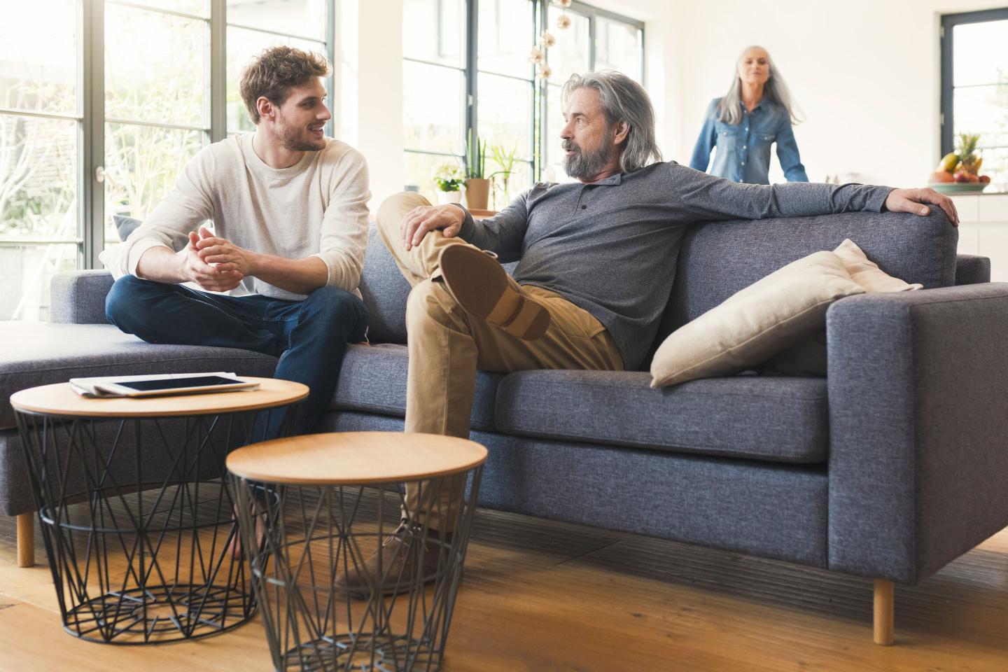 Son sitting on couch, talking to his father