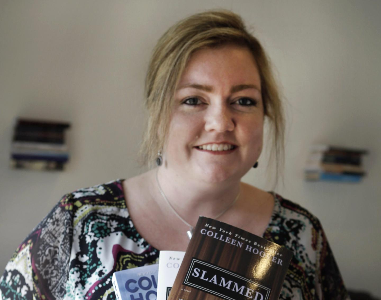 A woman smiling holding books