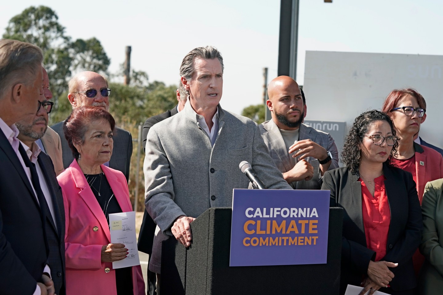 Gov. Gavin Newsom, center, is flanked by state lawmakers while discussing the package of legislation he signed that accelerates the climate goals of the nation's most populous state, at Mare Island in Vallejo, Calif., Sept. 16, 2022.