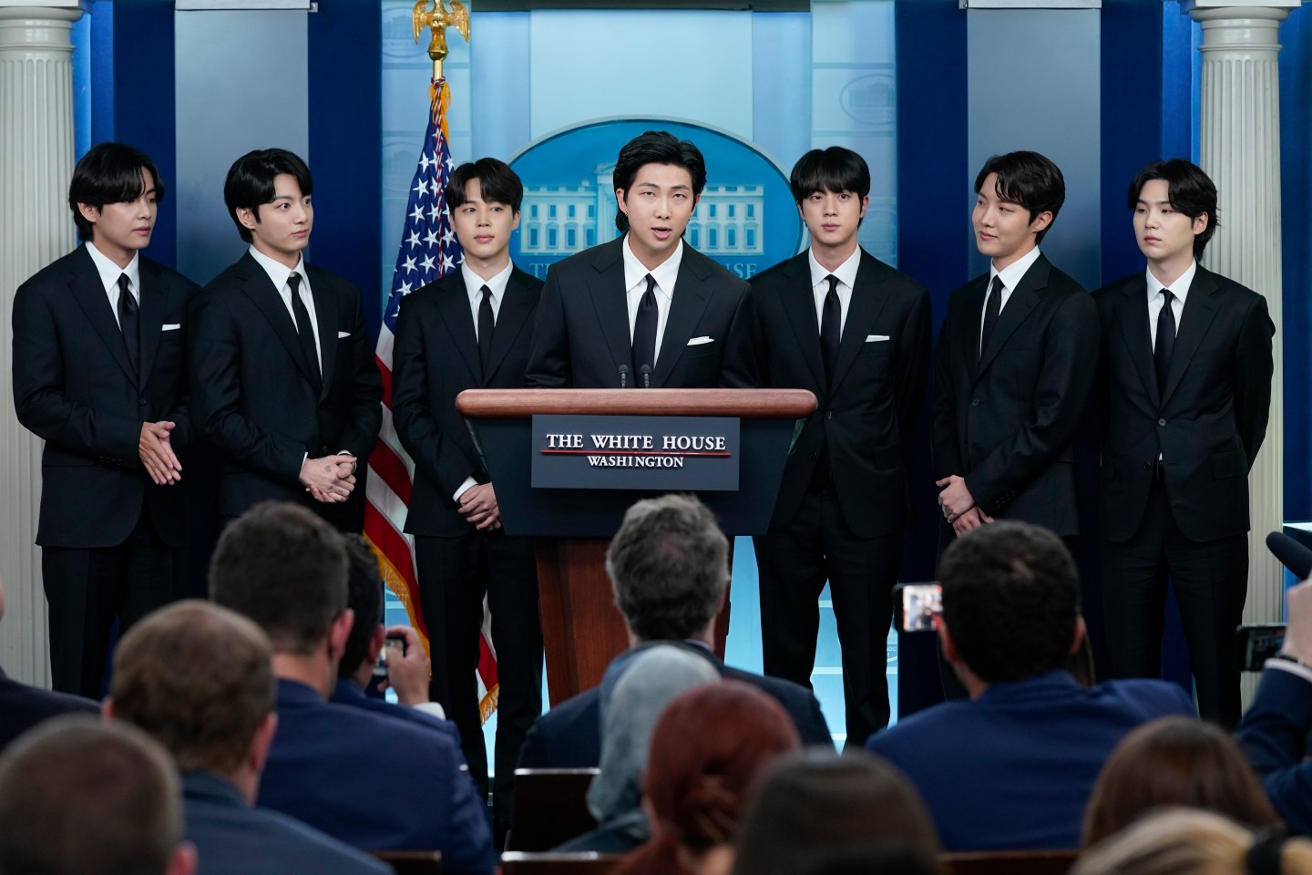 RM, center, accompanied by other K-pop supergroup BTS members from left, V, Jungkook, Jimin, Jin, J-Hope, and Suga speaks during the daily briefing at the White House in Washington, May 31, 2022.