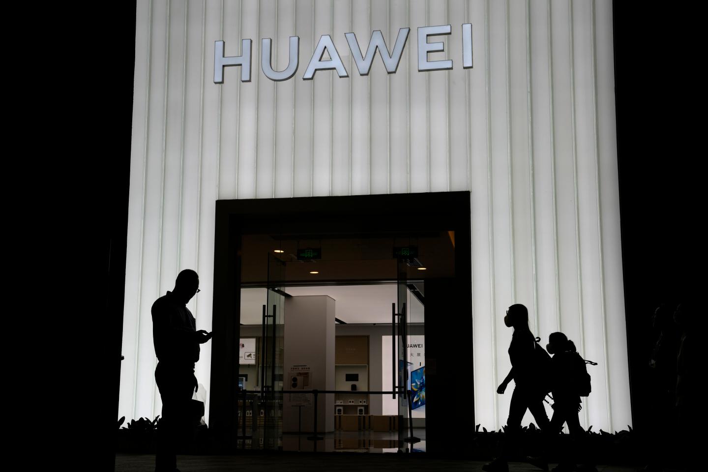 Shoppers pass by a Huawei store in Beijing, China