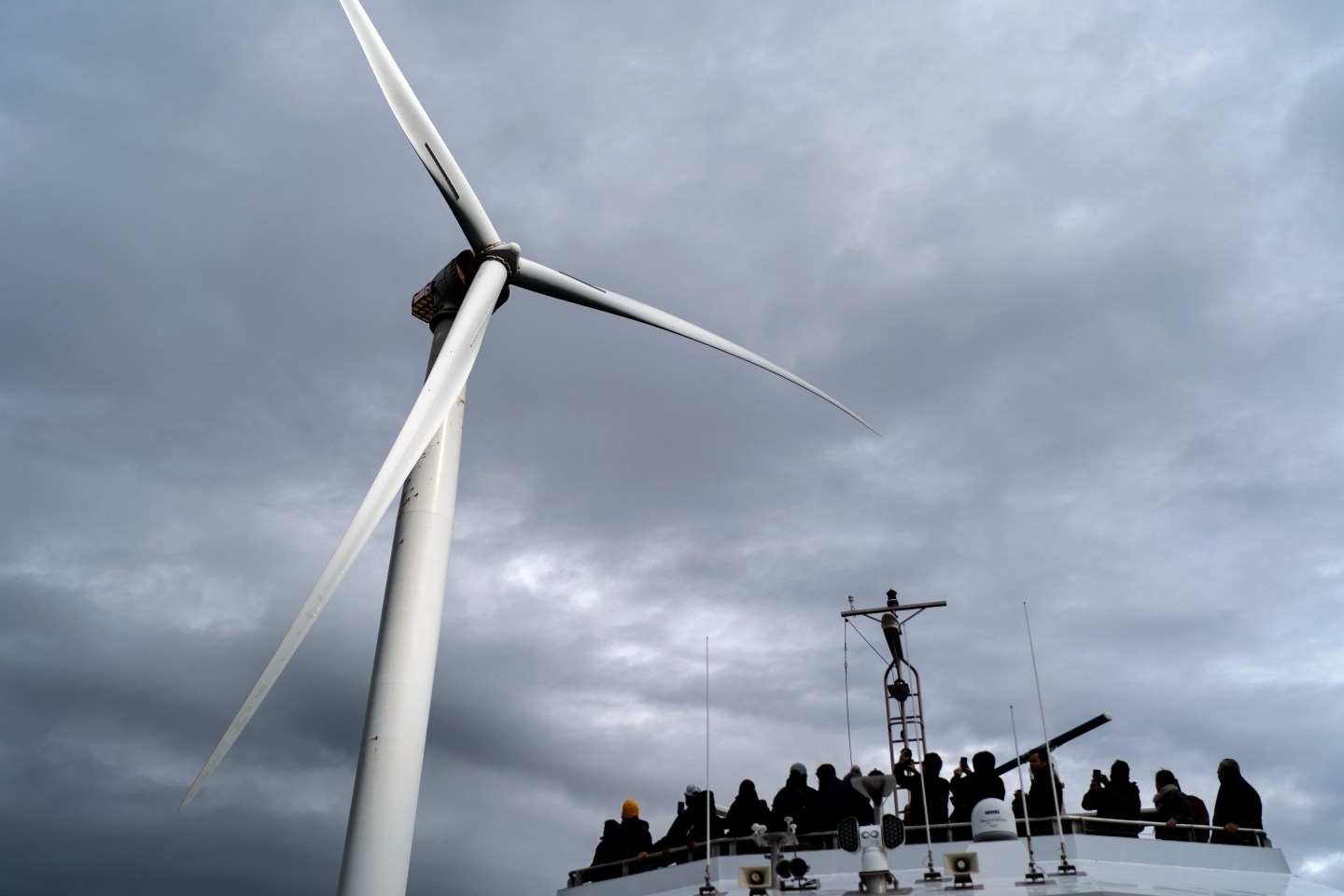 Guests tour one of the turbines of America's first offshore wind farm, owned by the Danish company, Orsted, off the coast of Block Island, R.I., as part of a wind power conference, Oct. 17, 2022. A new AP-NORC poll shows that nearly two-thirds of Americans think the federal government is not doing enough to fight climate change, even as they have limited awareness about a sweeping new law that commits the U.S. to its largest ever investment to combat global warming.