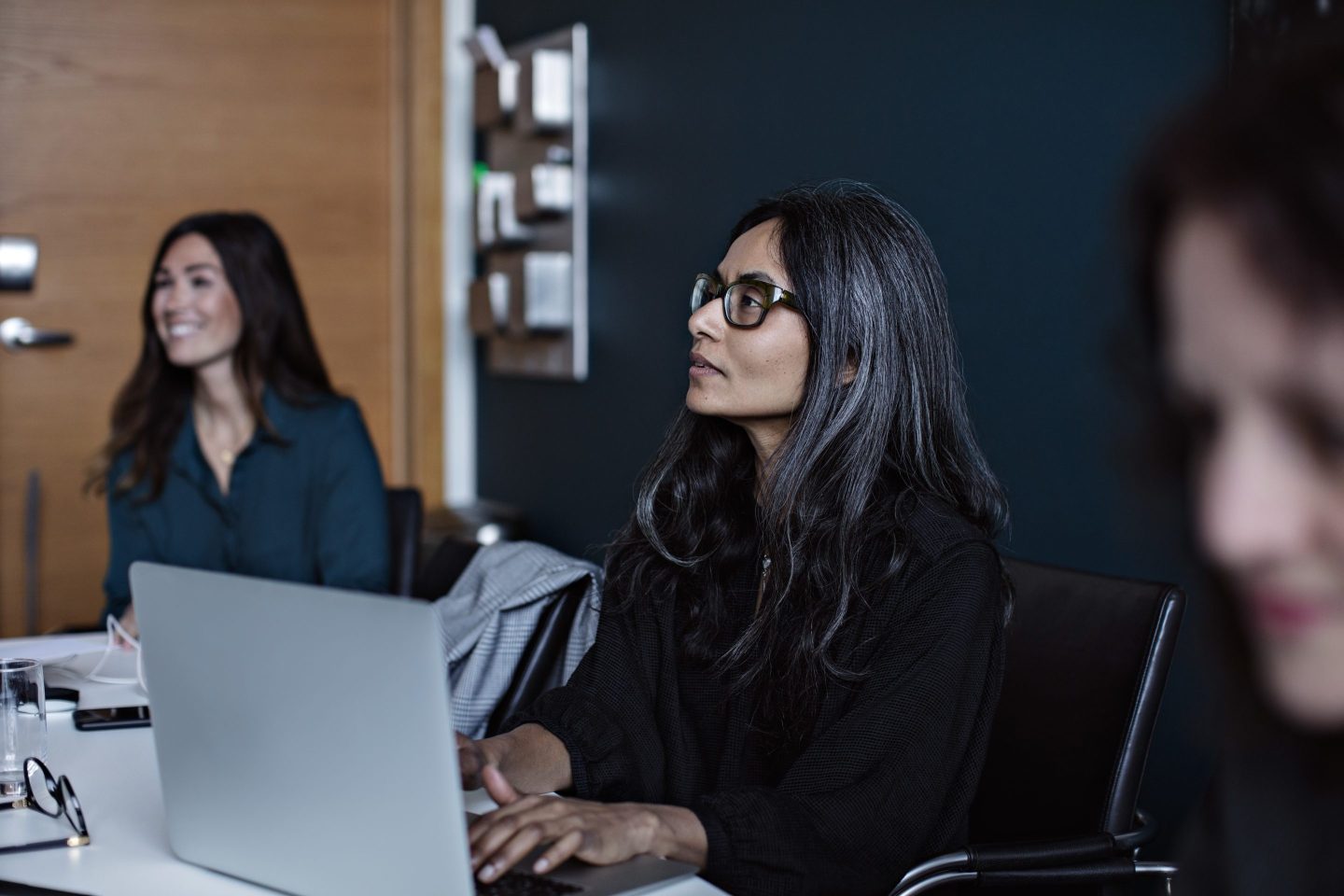 A woman in a suit leads a business meeting