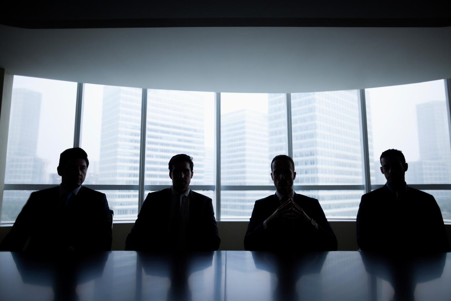 Silhouette row of businessmen sitting in meeting room