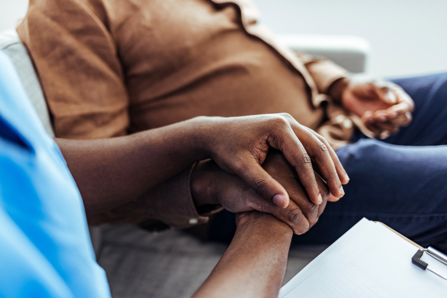 Home caregiver and senior man holding hands