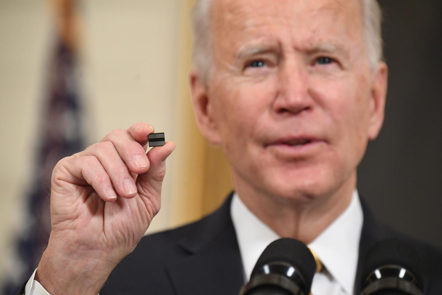 President Joe Biden holds a microchip as he speaks before signing an executive order on securing critical supply chains in Feb. 2021. The Biden administration has since taken several steps to encourage chipmakers to move production back to the U.S.