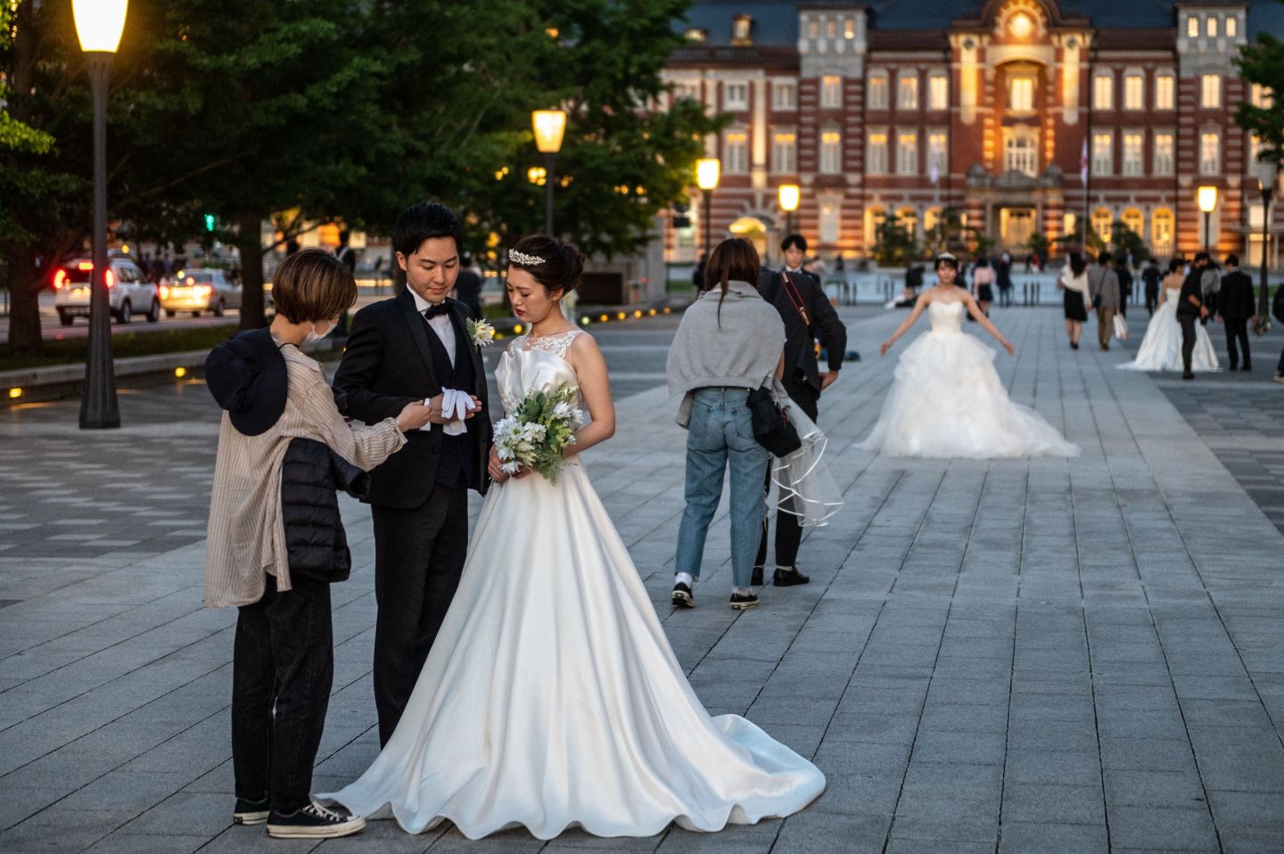 People prepare for a wedding photo shoot near Tokyo station during evening hour in Tokyo on May 23, 2021. 