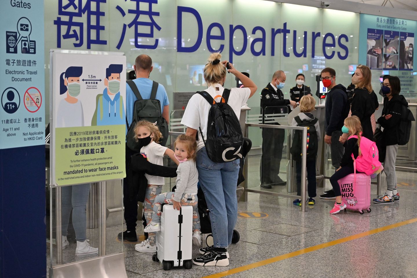 Expat familes depart Hong Kong's Chek Lap Kok international airport on March 6, 2022. The new visa seek to stem a brain drain following Hong Kong’s slow reopening of its international borders, with many foreigners leaving the city for alternative locations.