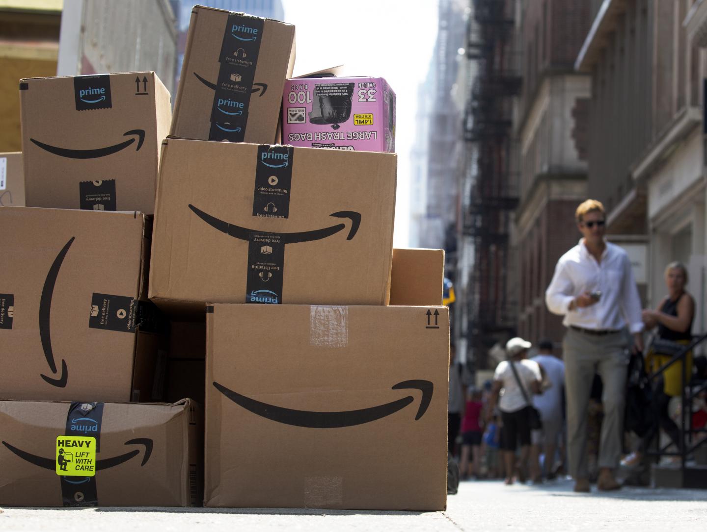 A pile of Amazon packages is seen on a busy sidewalk in New York.
