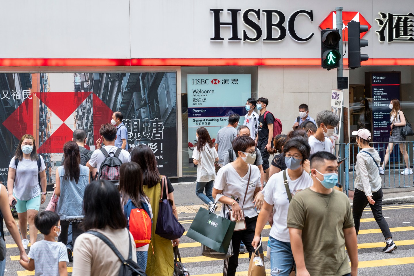 Pedestrians cross the street in front of HSBC Bank in Hong Kong.