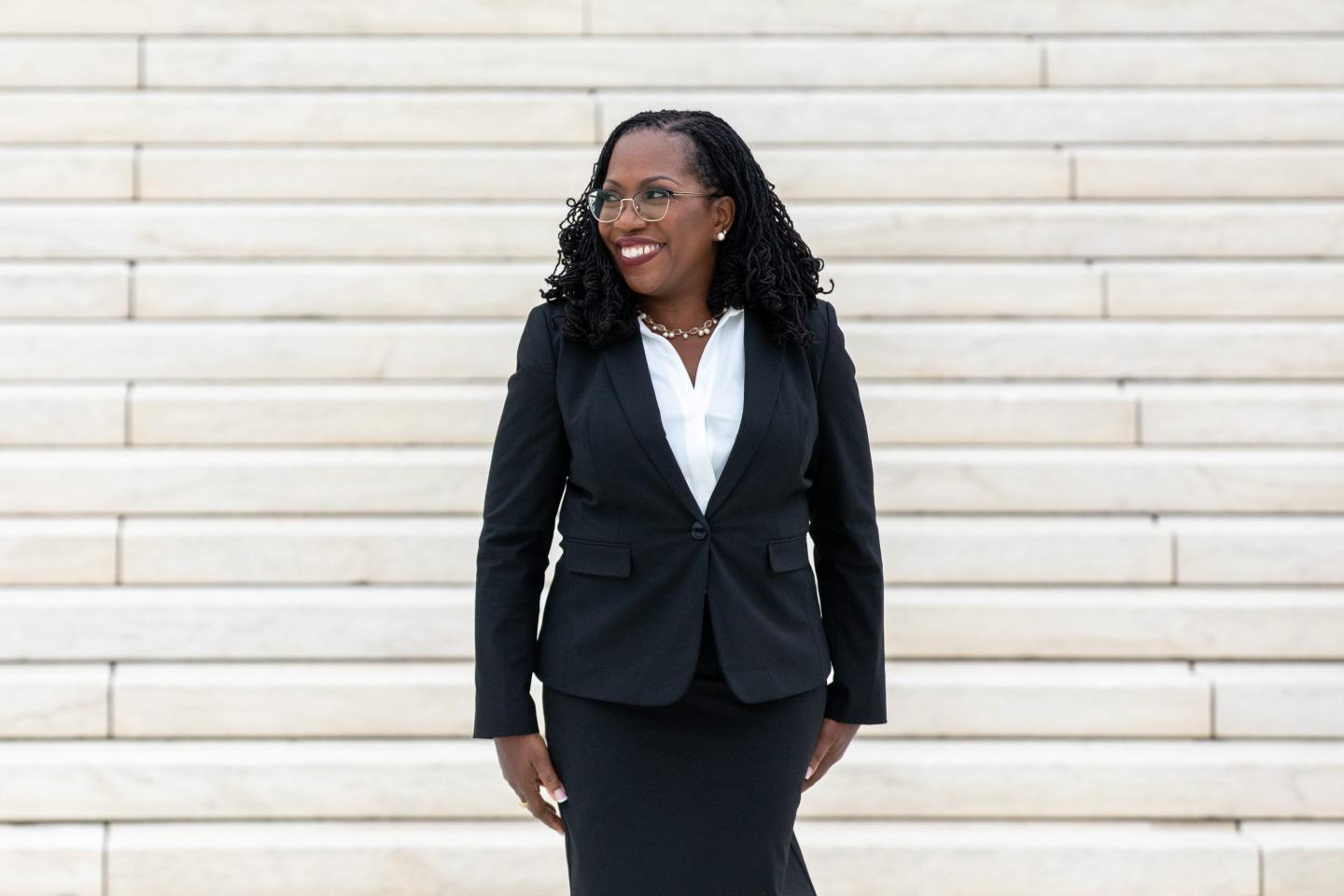 Justice Ketanji Brown Jackson stands on the steps of the Supreme Court building.