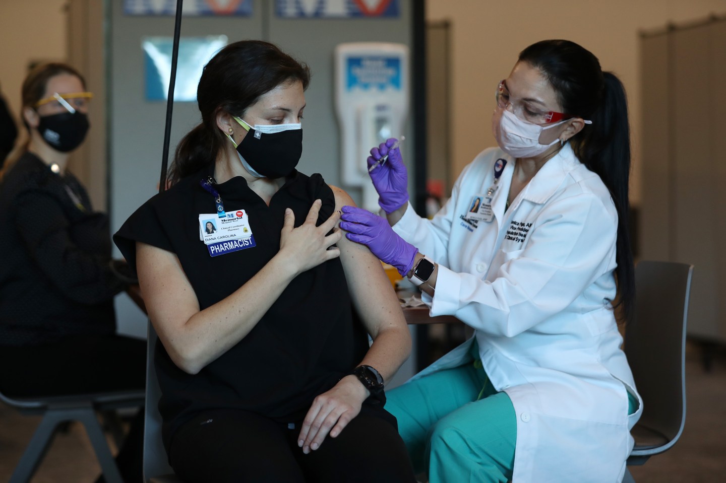 Diana Carolina, a pharmacist at Memorial Healthcare System, receives a Pfizer-BioNtech Covid-19 vaccine from Monica Puga, ARNP at Memorial Healthcare System, on December 14, 2020 in Miramar, Florida.