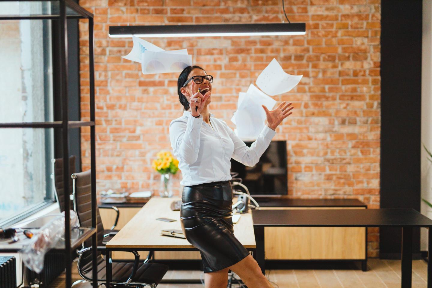 woman throwing papers in office