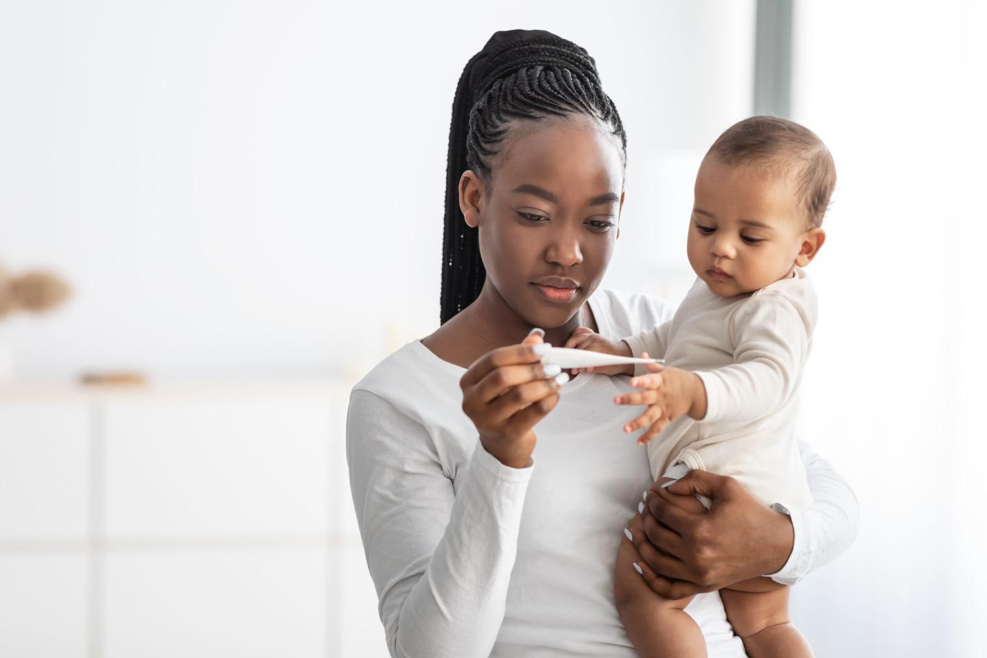Mother measuring child's temperature.