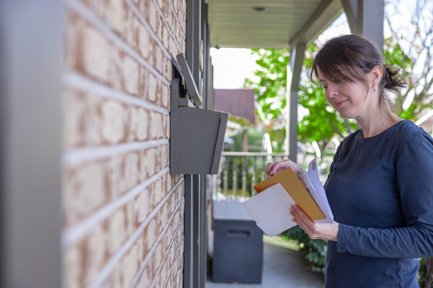 Woman Collecting Post at Home in her Mailbox in Australia