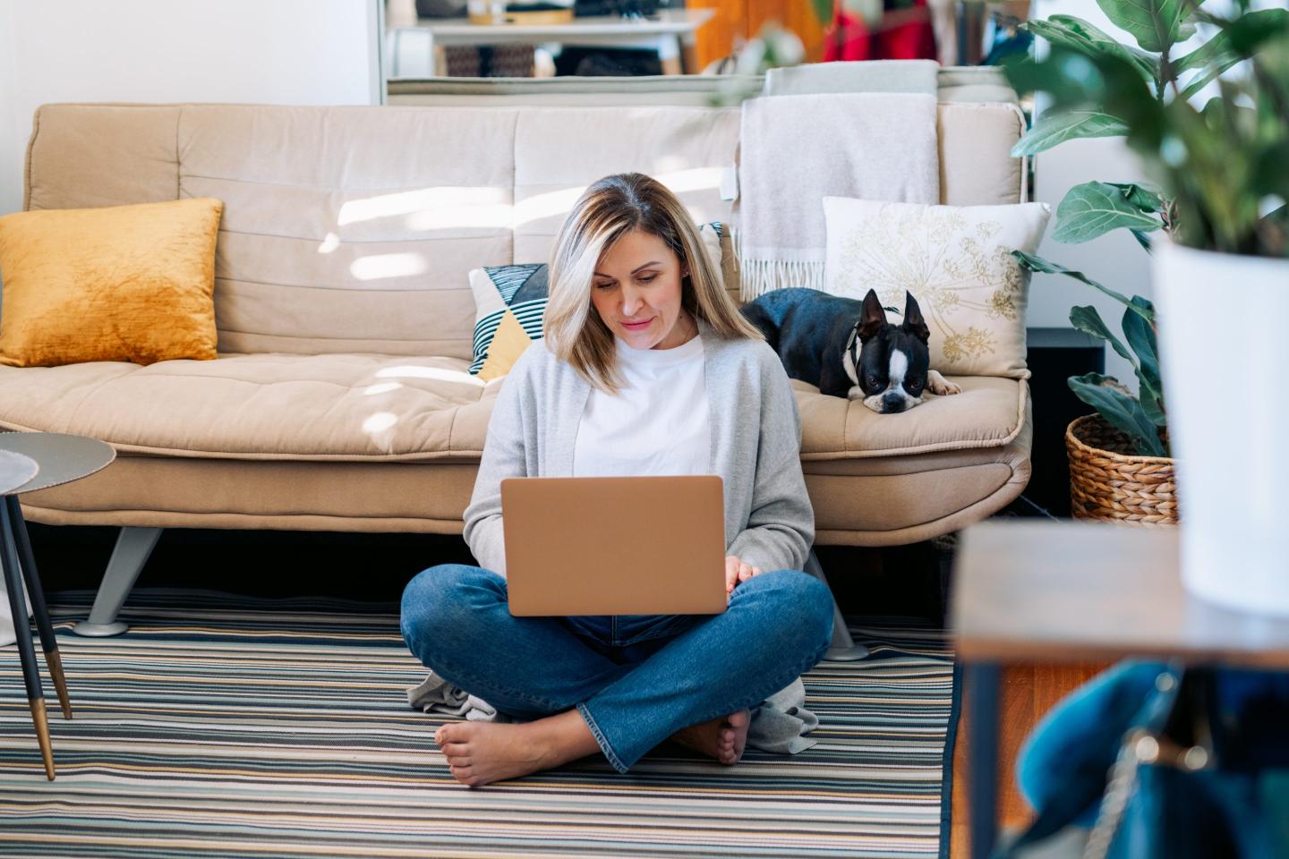 Woman working on couch with dog