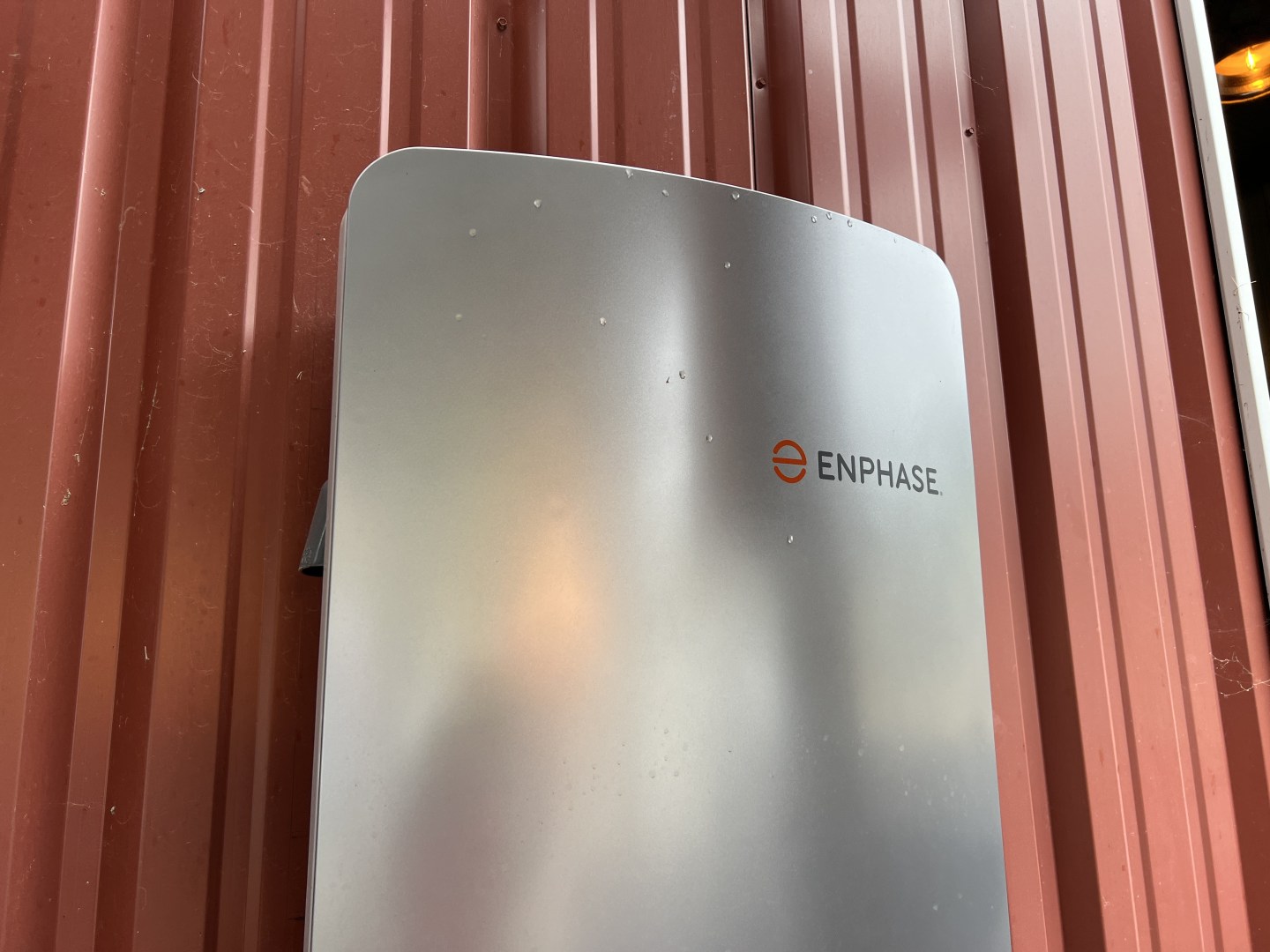 Enphase brand solar battery mounted on the wall of a barn in California.