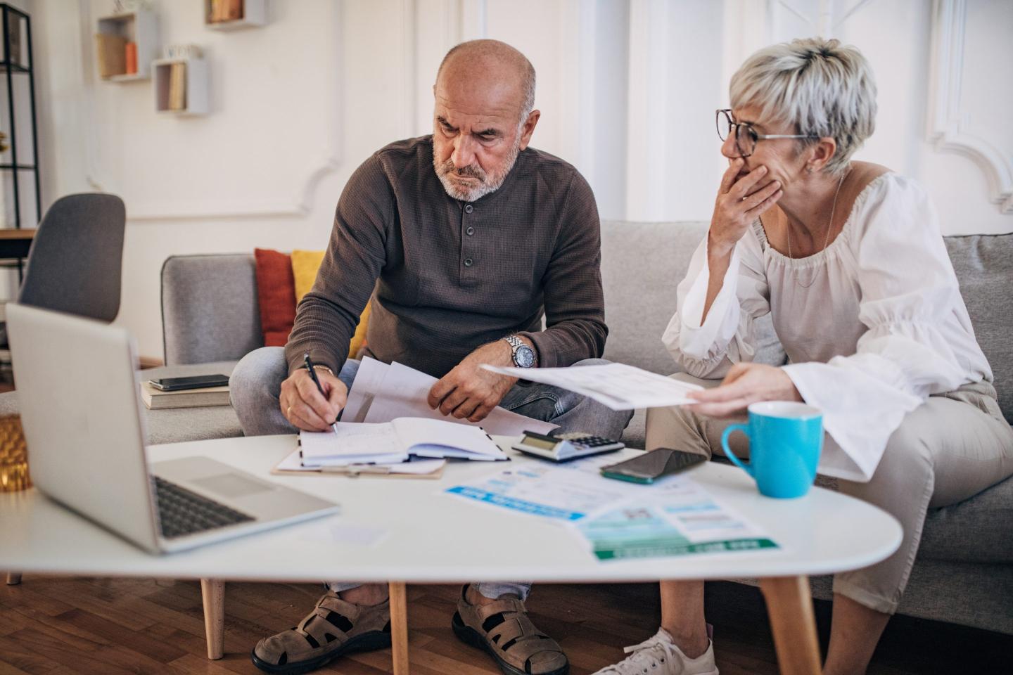 Couple calculating bills and taxes and home and trying to organise to pay them