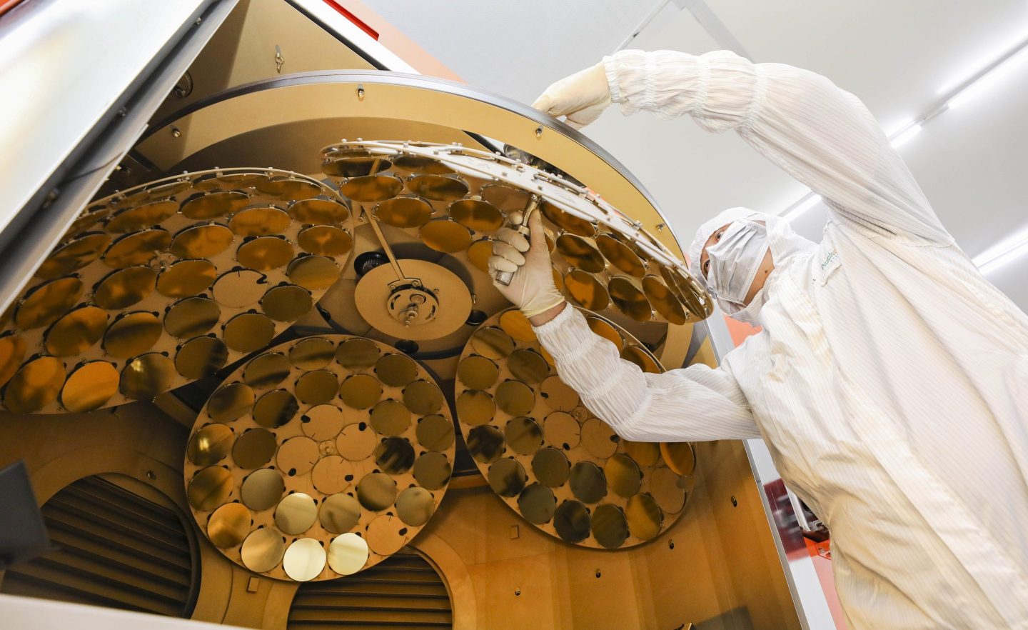 A Chinese worker in protective gear works in a Chinese semiconductor waver factory