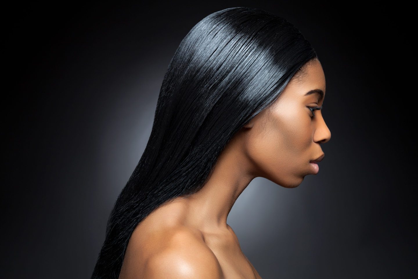 Profile of an young black beauty with long straight and shiny hair