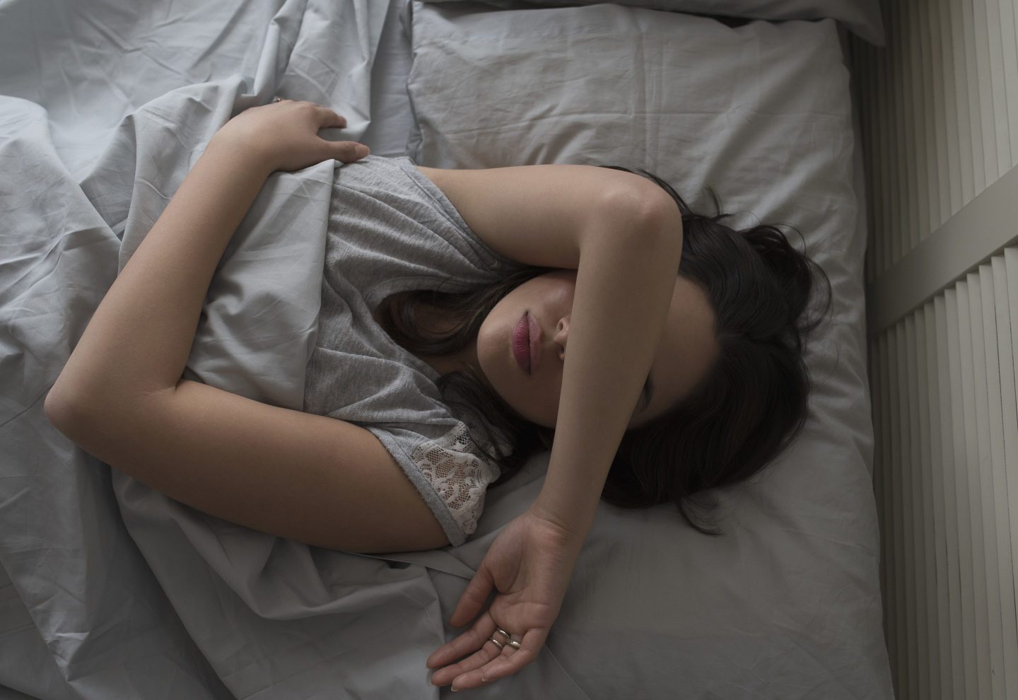 overhead view of young woman sleeping in bed