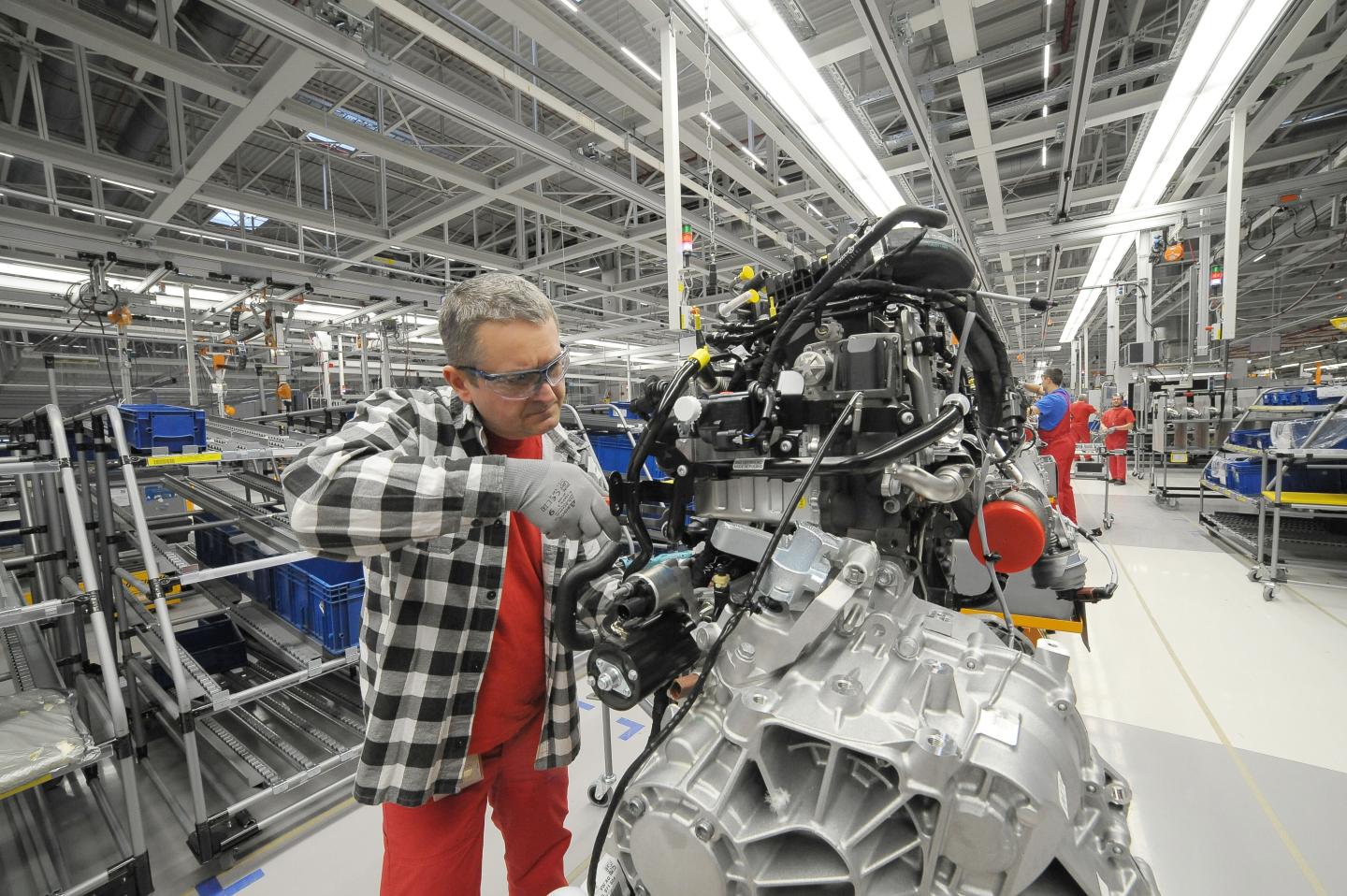 An employee works on an engine at a Volkswagen manufacturing plant in Poland