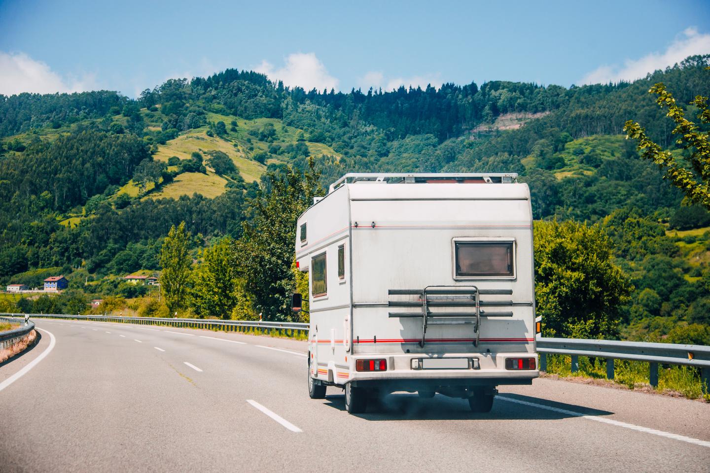 A van on a highway next to a mountain range