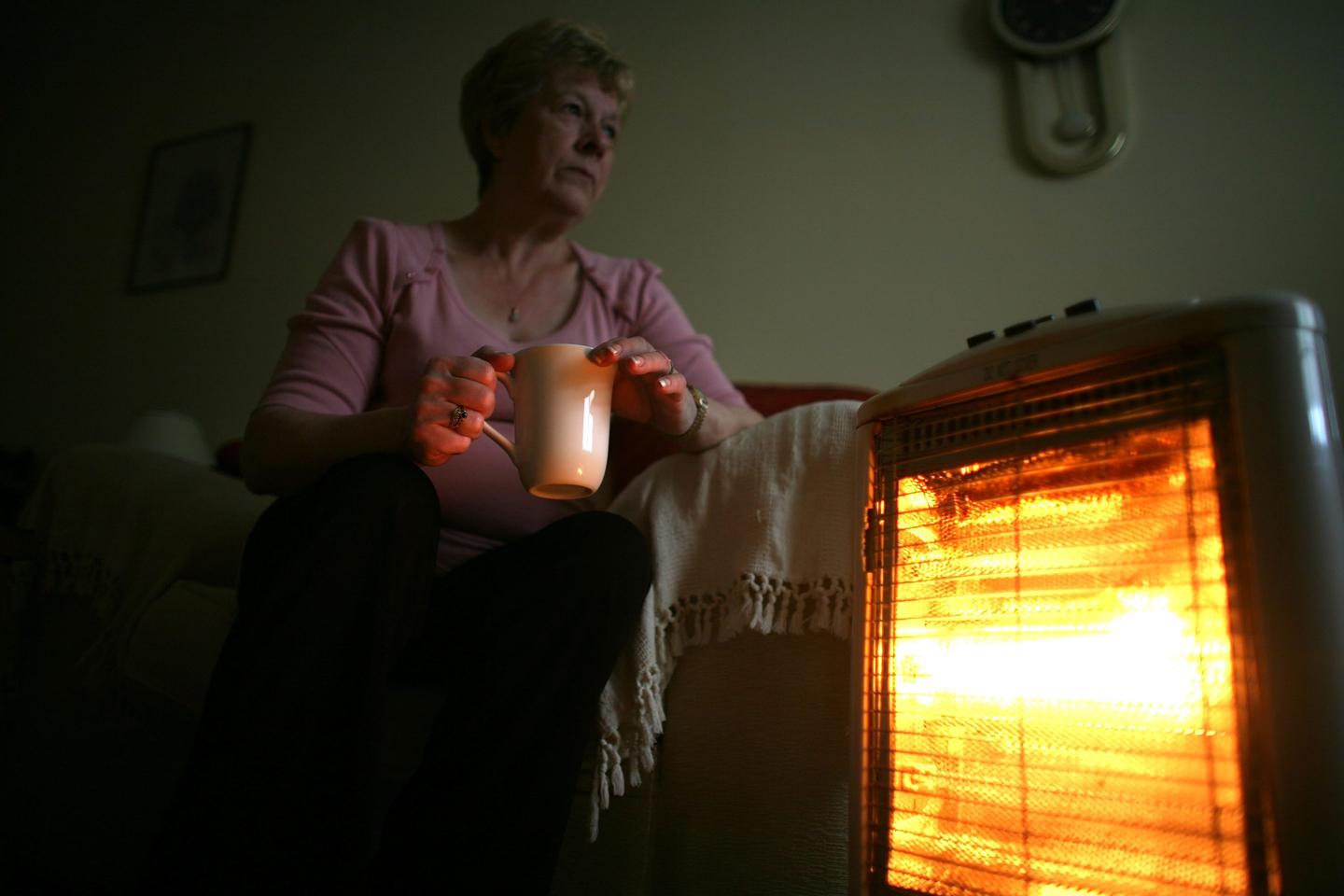 In this photo illustration an old age pensioner keeps warm with the aid of an electric heater on November 6, 2008, in Conwy, Wales.