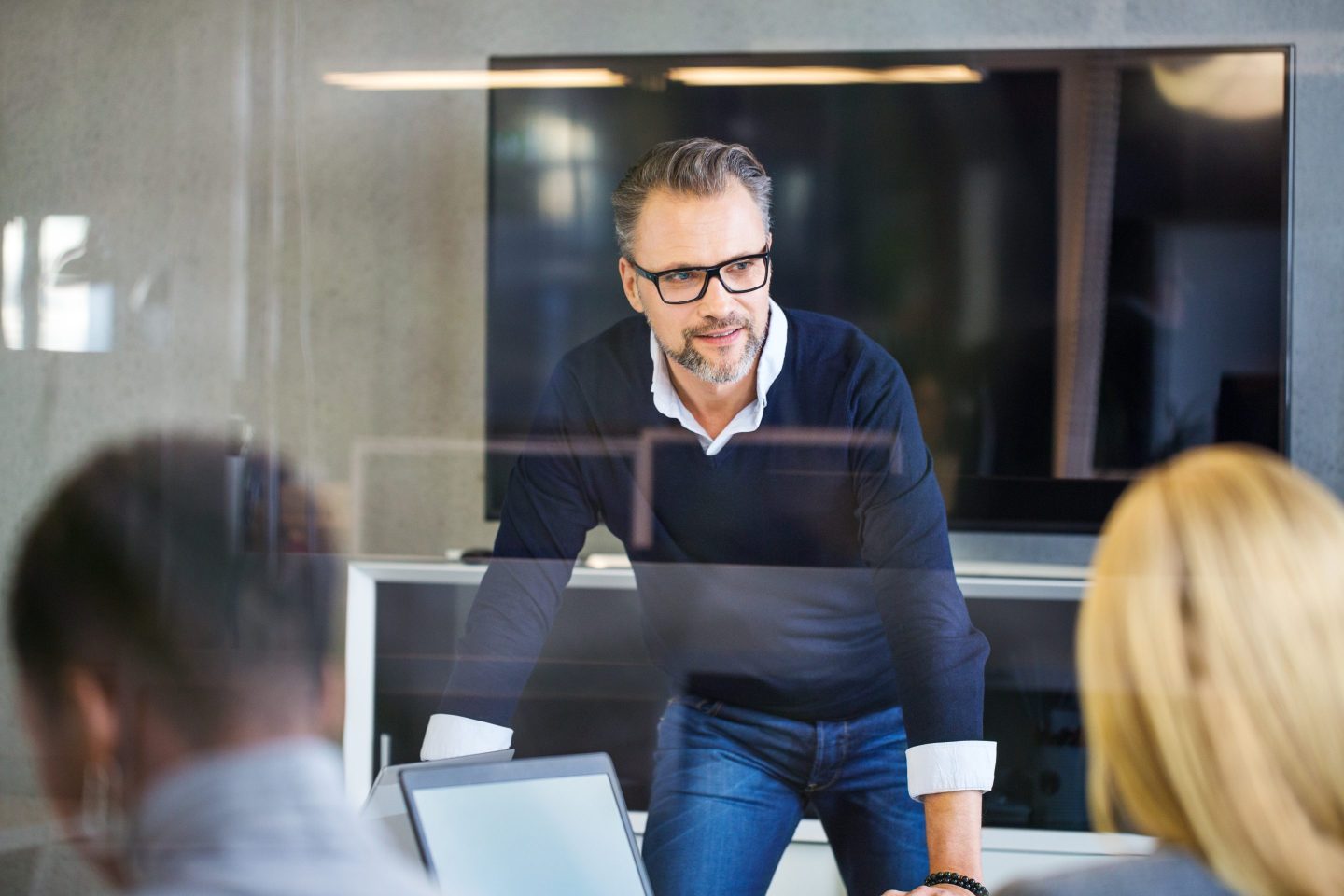 Mature white businessman having discussion in meeting room with colleagues
