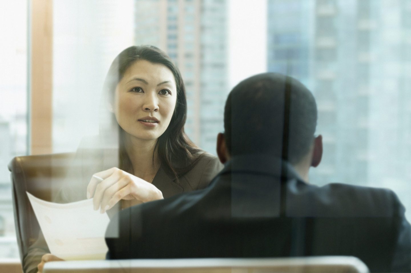 Business people talking behind window in office meeting