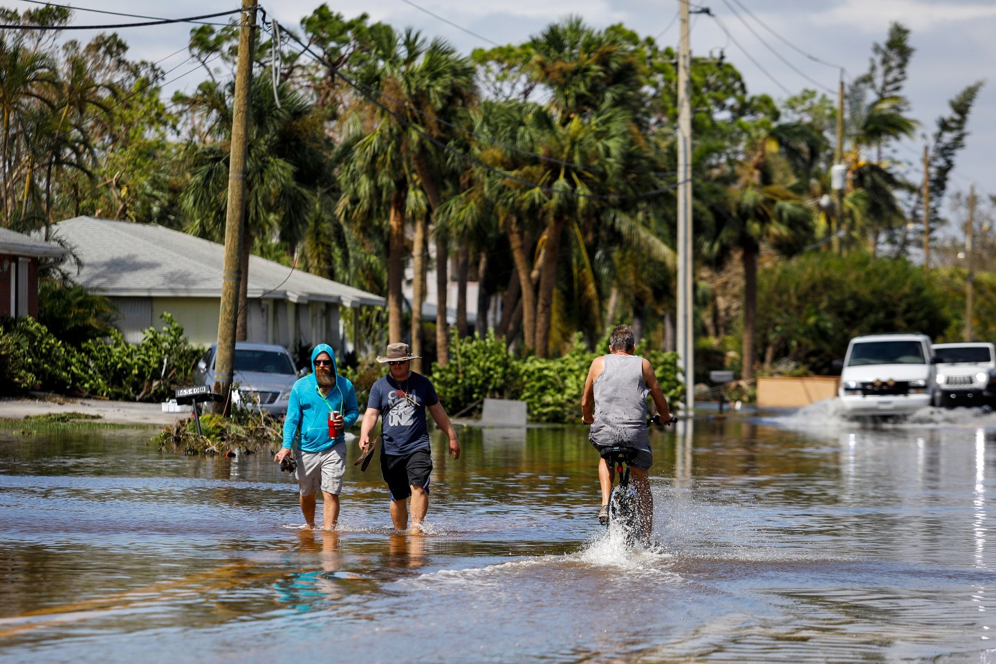 People walk on a flooded street following Hurricane Ian in Fort Myers, Florida, US, on Thursday, Sept. 29, 2022.