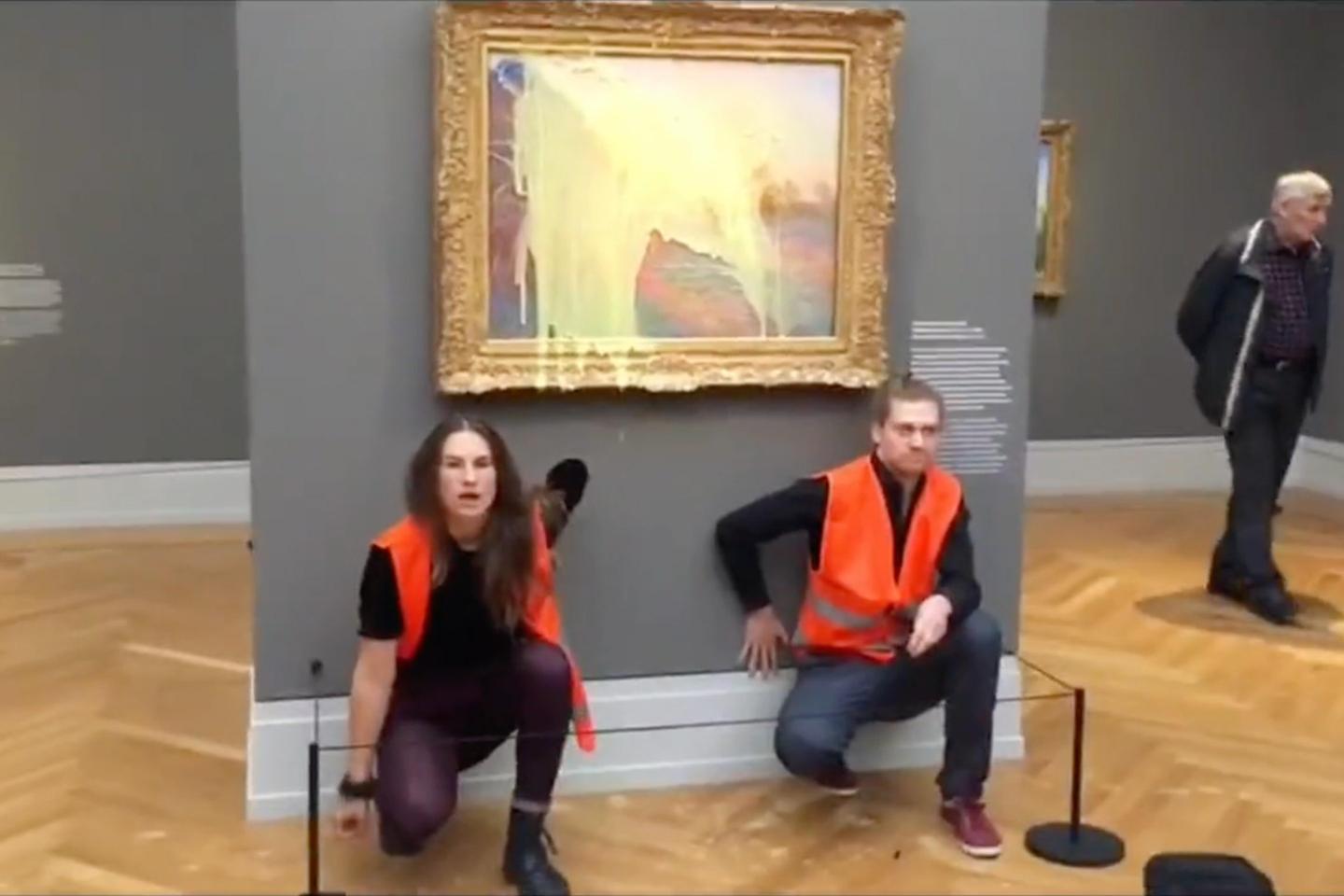 Two climate activists kneel down in front of "Haystacks" painting by Claude Monet after covering it in mashed potatoes