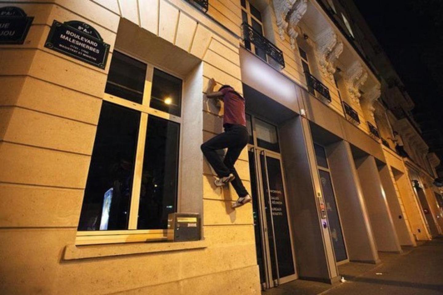 Member of On The Spot parkour group climbs wall to switch off shop lights