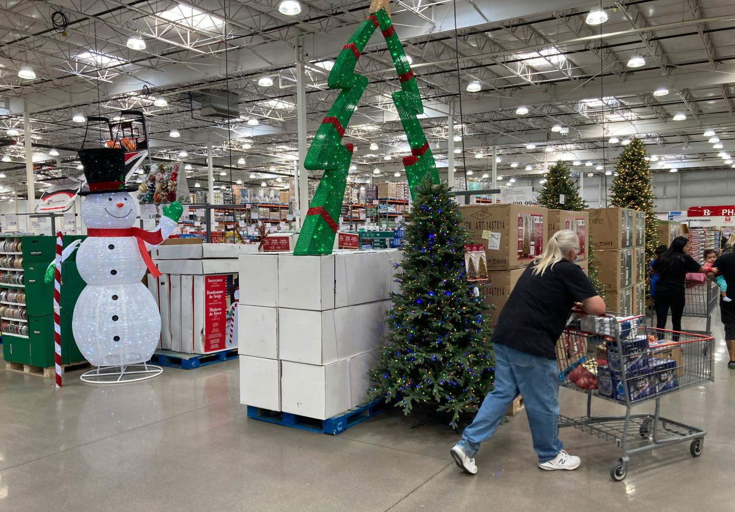 Shoppers pass by display of Christmas items