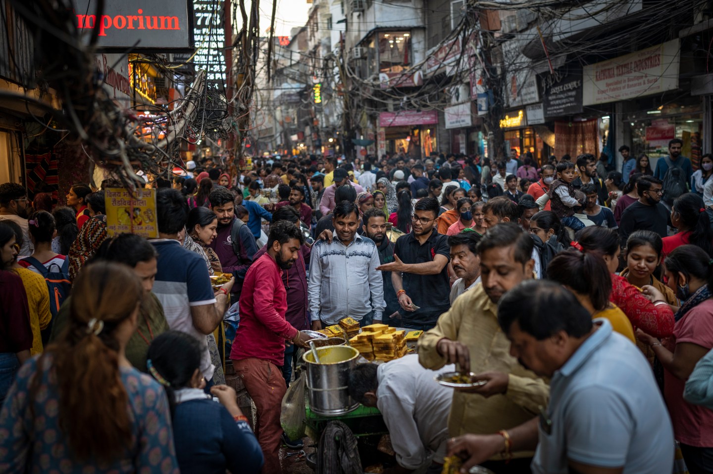 People eat street food as shoppers crowd a market in New Delhi, India, Nov. 12, 2022. The world's population is projected to hit an estimated 8 billion people on Nov. 15, according to a UN projection.