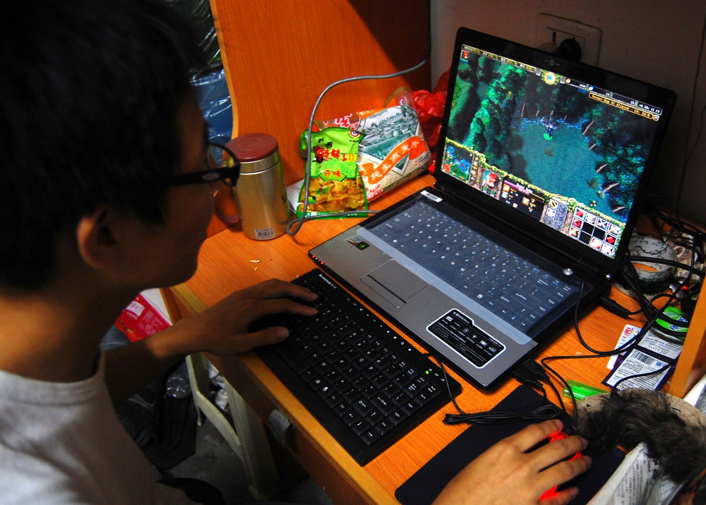 A college student plays the online game World of Warcraft in his dormitory room in southwest China's Chongqing city.