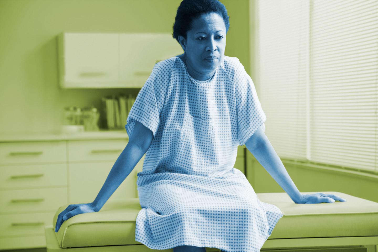 Female patient sitting on examination table in doctor's office