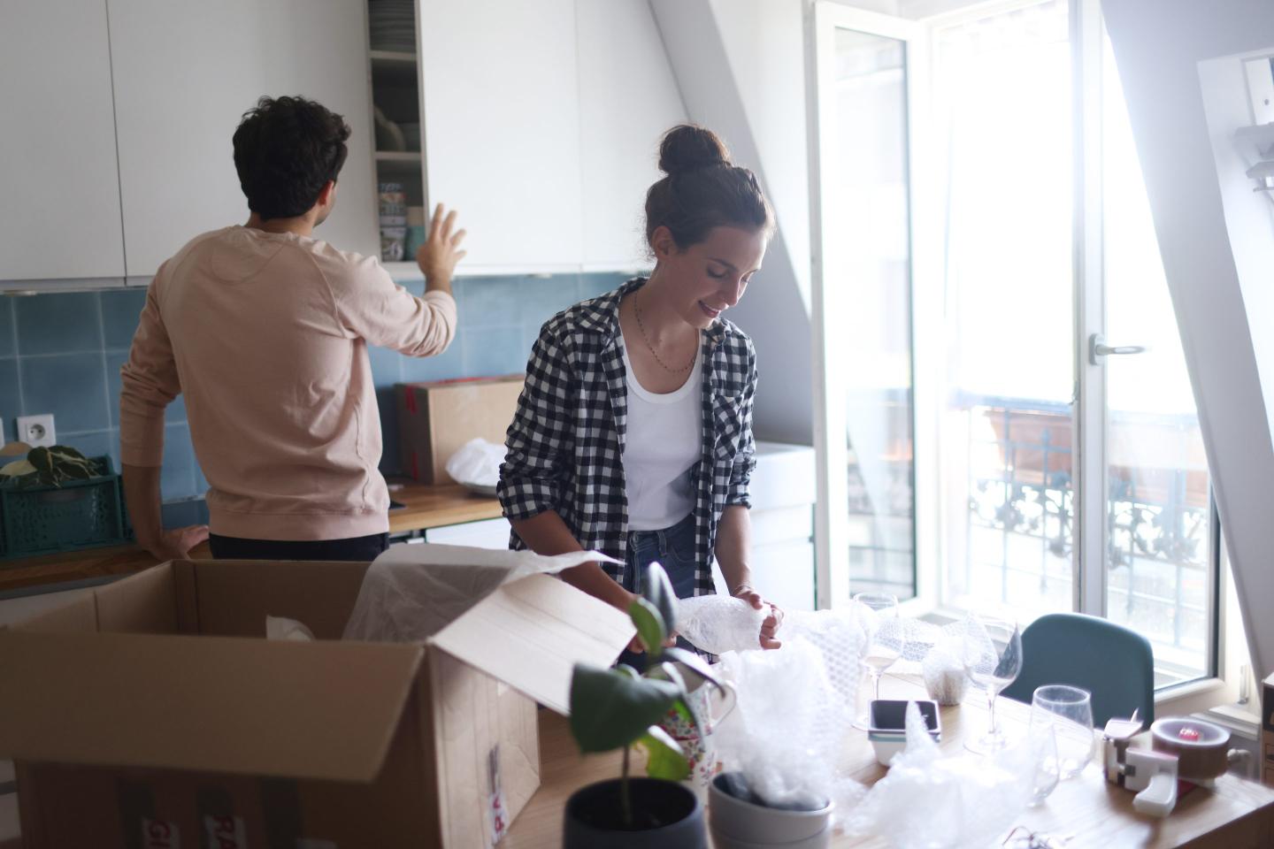 Couple packing boxes for move