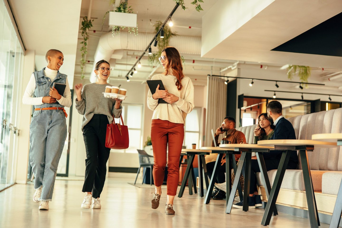 Three businesswomen walking through an office