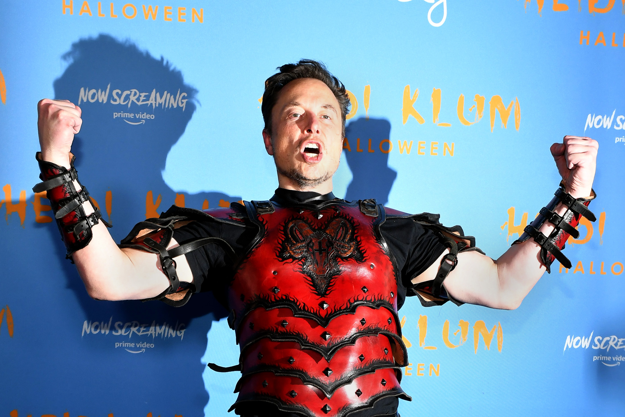 A picture of Musk in a Halloween costume, flexing his arms.