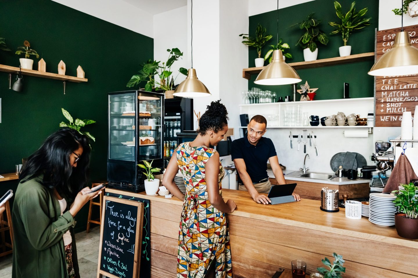 A customer looking at a barista’s tablet in a coffee shop