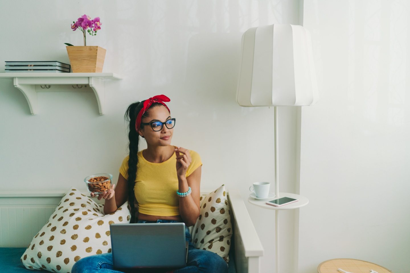 Woman working from home eating almonds.