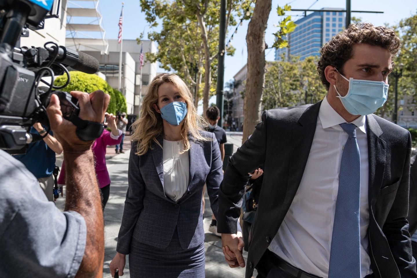 Elizabeth Holmes, founder of Theranos, and husband Billy Evans exit federal court in San Jose, Sept. 8, 2021.