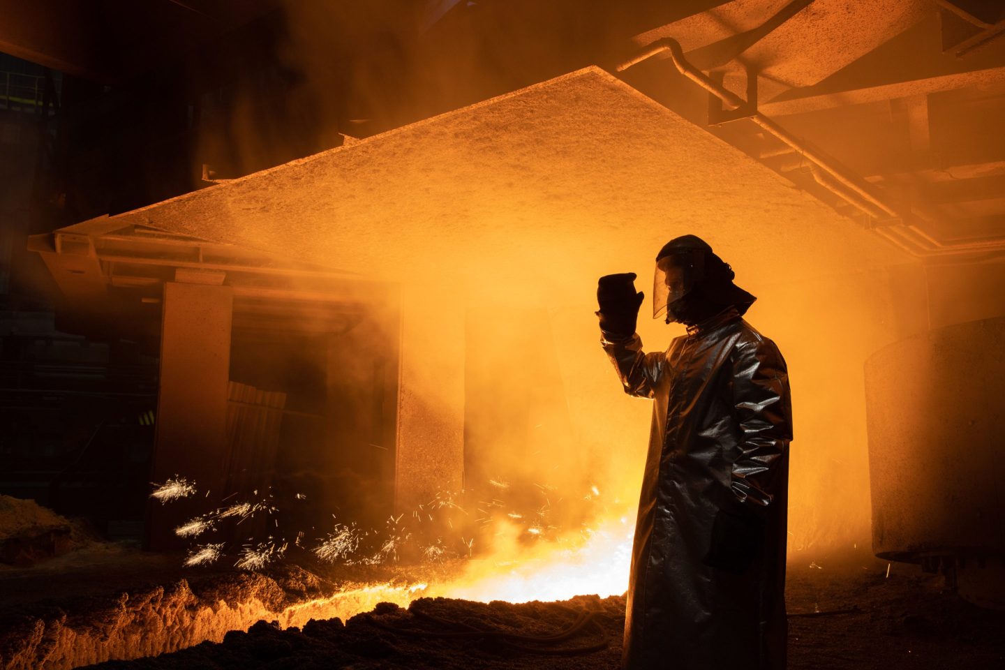 An employee inspecting a traditional blast furnace at a steel mill in Russia.