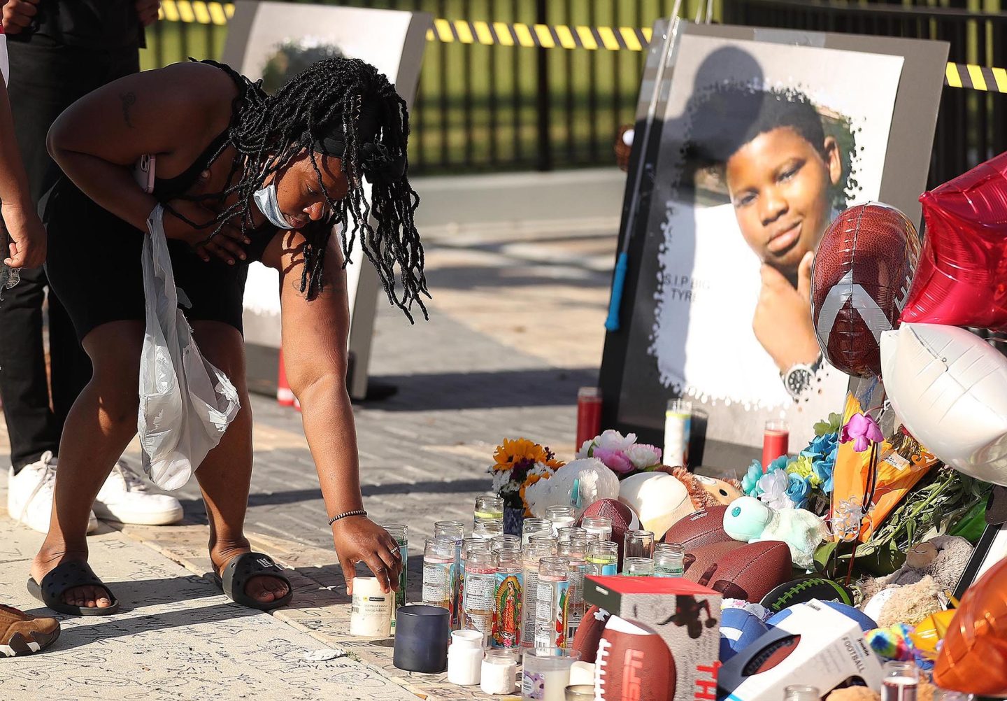 Family members and friends of Tyre Sampson leave items during a vigil in front of the Orlando Free Fall drop tower