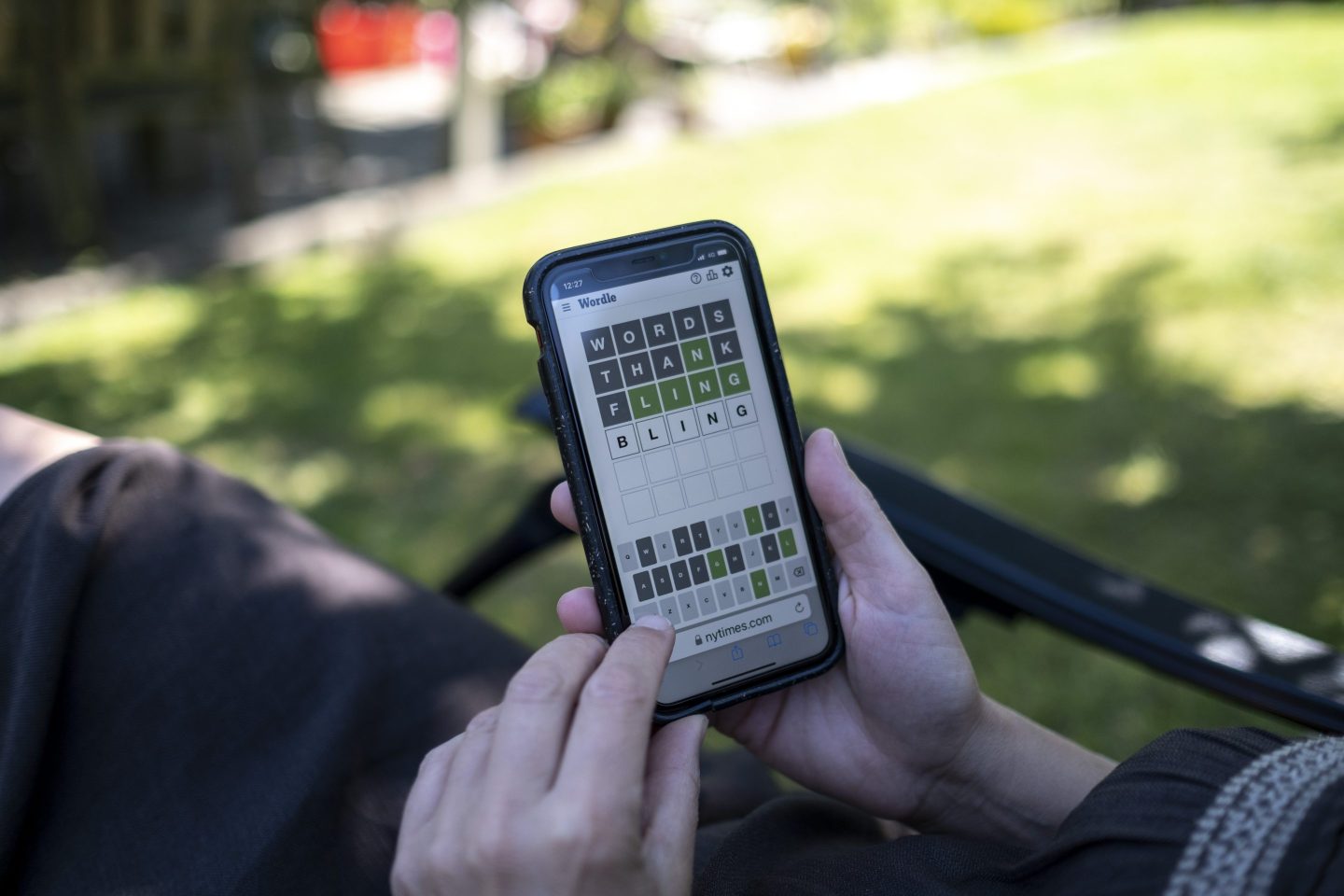 A woman plays Wordle on her phone
