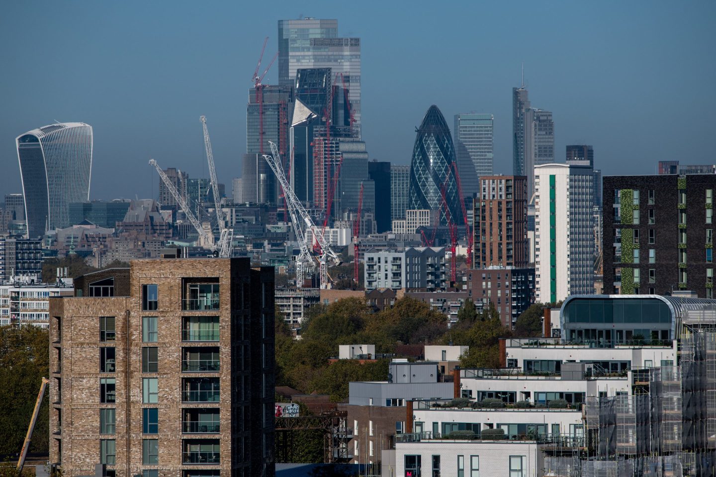 Residential housing is seen in front of skyscrapers in the city of London